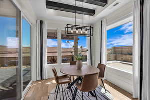 Dining space with light wood finished floors and a raised ceiling
