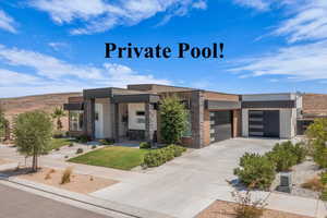 Contemporary home featuring stone siding, stucco siding, an attached garage, and concrete driveway