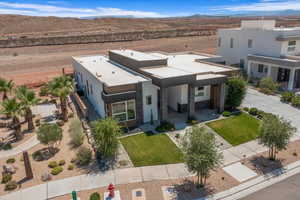 Contemporary home with stone siding, stucco siding, a mountain view, view of desert, and a front yard