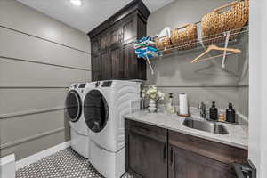 Laundry room with cabinet space, washer and dryer, and tile patterned flooring