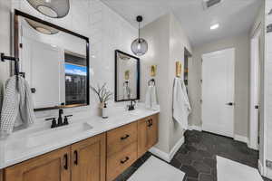 Full bath featuring double vanity, tile patterned floors, and recessed lighting