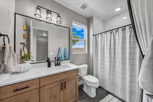 Bathroom featuring vanity, curtained shower, and wood finished floors