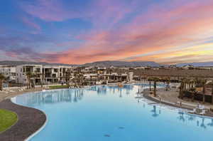Pool at dusk with a community pool and a mountain view