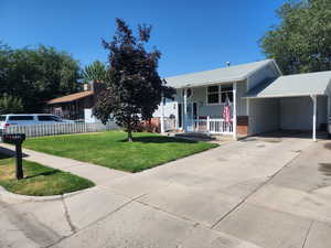 View of front of house with brick siding, a porch, an attached carport, driveway, and board and batten siding
