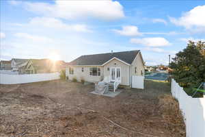 Back of house featuring a fenced backyard and a shingled roof