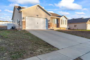 Ranch-style house featuring a garage, concrete driveway, and brick siding