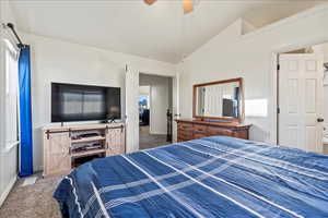 Carpeted bedroom with vaulted ceiling and a ceiling fan