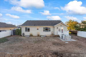 Rear view of house with a fenced backyard, a shed, and roof with shingles