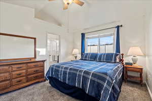Bedroom with lofted ceiling, light carpet, a ceiling fan, and ensuite bathroom