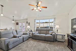 Living room featuring carpet floors, a ceiling fan, and french doors