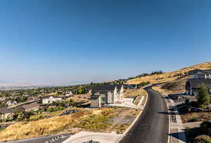 View of asphalt street with a residential view, a mountain view, and curbs