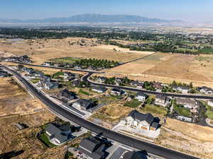 Aerial overview of property's location with rural landscape, a mountain backdrop, and nearby suburban area