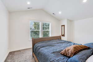 Carpeted bedroom with lofted ceiling and recessed lighting