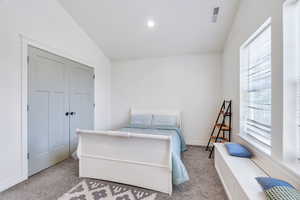 Bedroom featuring vaulted ceiling and carpet