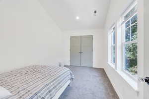 Bedroom with carpet flooring, vaulted ceiling, recessed lighting, and a closet