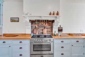 Kitchen with open shelves, high end stainless steel range oven, and butcher block countertops