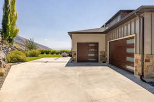 Garage featuring concrete driveway and a mountain view