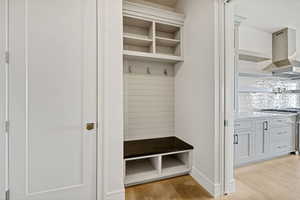 Mudroom with light wood finished floors and baseboards