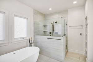 Bathroom with a shower stall, a soaking tub, tile patterned floors, and recessed lighting
