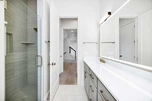 Full bathroom featuring vanity, a stall shower, and tile patterned floors