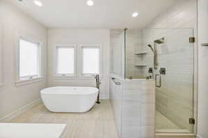 Full bathroom with a stall shower, a soaking tub, recessed lighting, and tile patterned floors