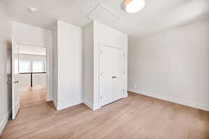 Unfurnished bedroom featuring light wood-style flooring and a closet