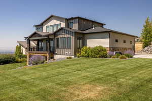 View of front facade with a front lawn and board and batten siding