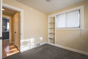 Carpeted empty room with baseboards