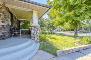 View of grassy yard with a porch