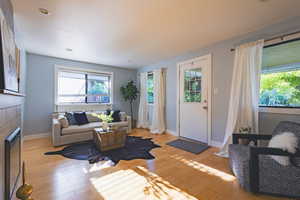 Living area featuring a fireplace, plenty of natural light, light wood-type flooring, and recessed lighting