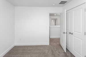 Unfurnished bedroom featuring carpet flooring and a closet
