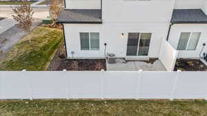 Rear view of house featuring a shingled roof and stucco siding