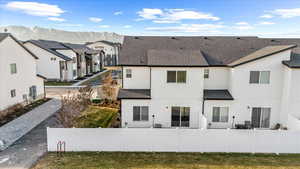 Rear view of house with a residential view, roof with shingles, a mountain view, and stucco siding