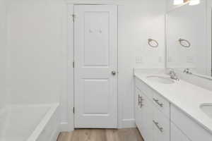 Bathroom with double vanity and wood finished floors