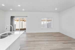 Unfurnished dining area with light wood-style floors and recessed lighting
