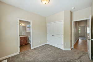 Unfurnished bedroom featuring carpet floors, a closet, and ensuite bathroom