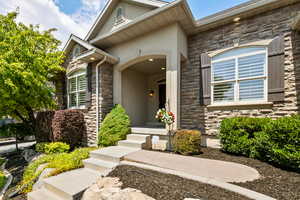 View of exterior entry featuring stone siding and stucco siding