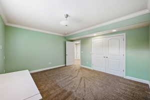 Unfurnished bedroom with carpet floors, crown molding, a closet, and recessed lighting