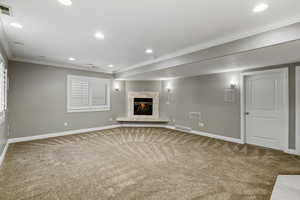 Below grade area featuring crown molding, carpet flooring, recessed lighting, and a high end fireplace