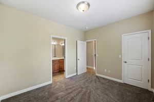 Unfurnished bedroom with carpet flooring and connected bathroom