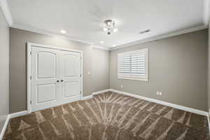 Unfurnished bedroom featuring ornamental molding, carpet floors, recessed lighting, and a closet