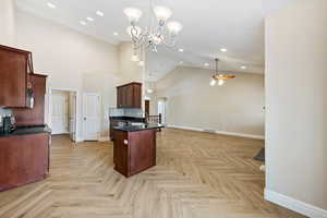 Kitchen featuring arched walkways, open floor plan, decorative backsplash, dark countertops, and ceiling fan