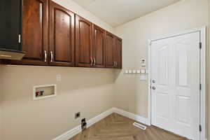 Laundry area with cabinet space, hookup for an electric dryer, and hookup for a washing machine