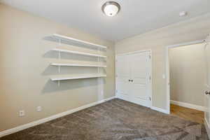 Unfurnished bedroom with a closet and dark carpet