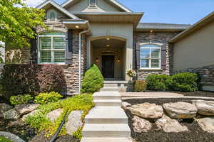 View of exterior entry with stone siding and stucco siding