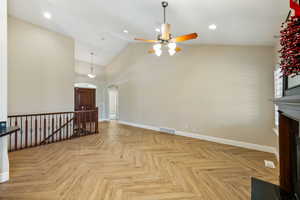 Unfurnished living room with arched walkways, a fireplace with flush hearth, recessed lighting, high vaulted ceiling, and ceiling fan