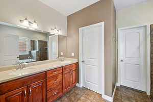 Bathroom featuring double vanity, a shower stall, and a bath