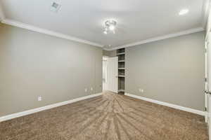 Unfurnished bedroom featuring carpet and crown molding