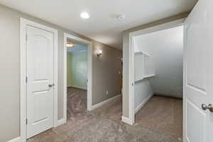 Hallway featuring carpet and baseboards
