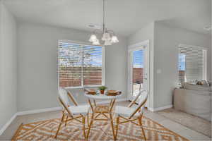 Dining area featuring light tile patterned floors and a chandelier